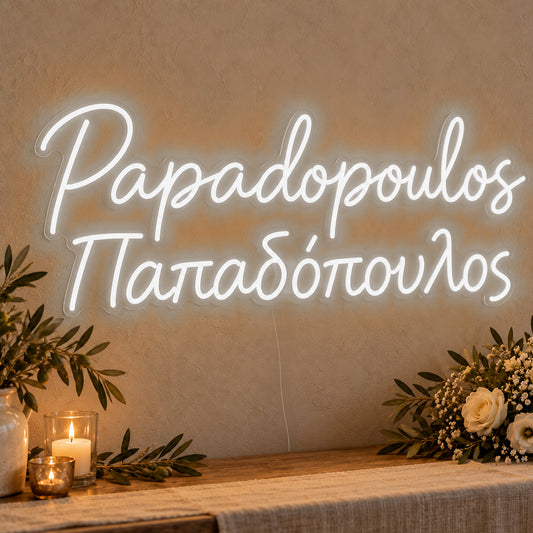 Personalised Bilingual Greek Surname Neon Sign in white LED neon on clear acrylic, angled view