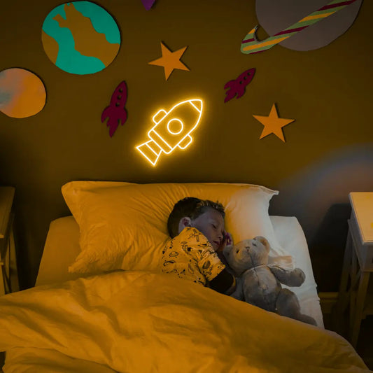 Rocket LED Neon Light Sign in yellow, featuring rocket outline illuminated on a space-themed bedroom wall.