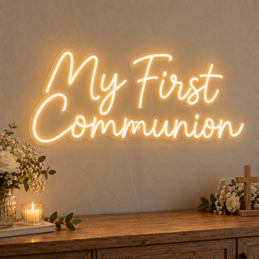 First Communion Neon Sign on clear cut-to-shape acrylic, illuminated on a wall in a styled celebration setting