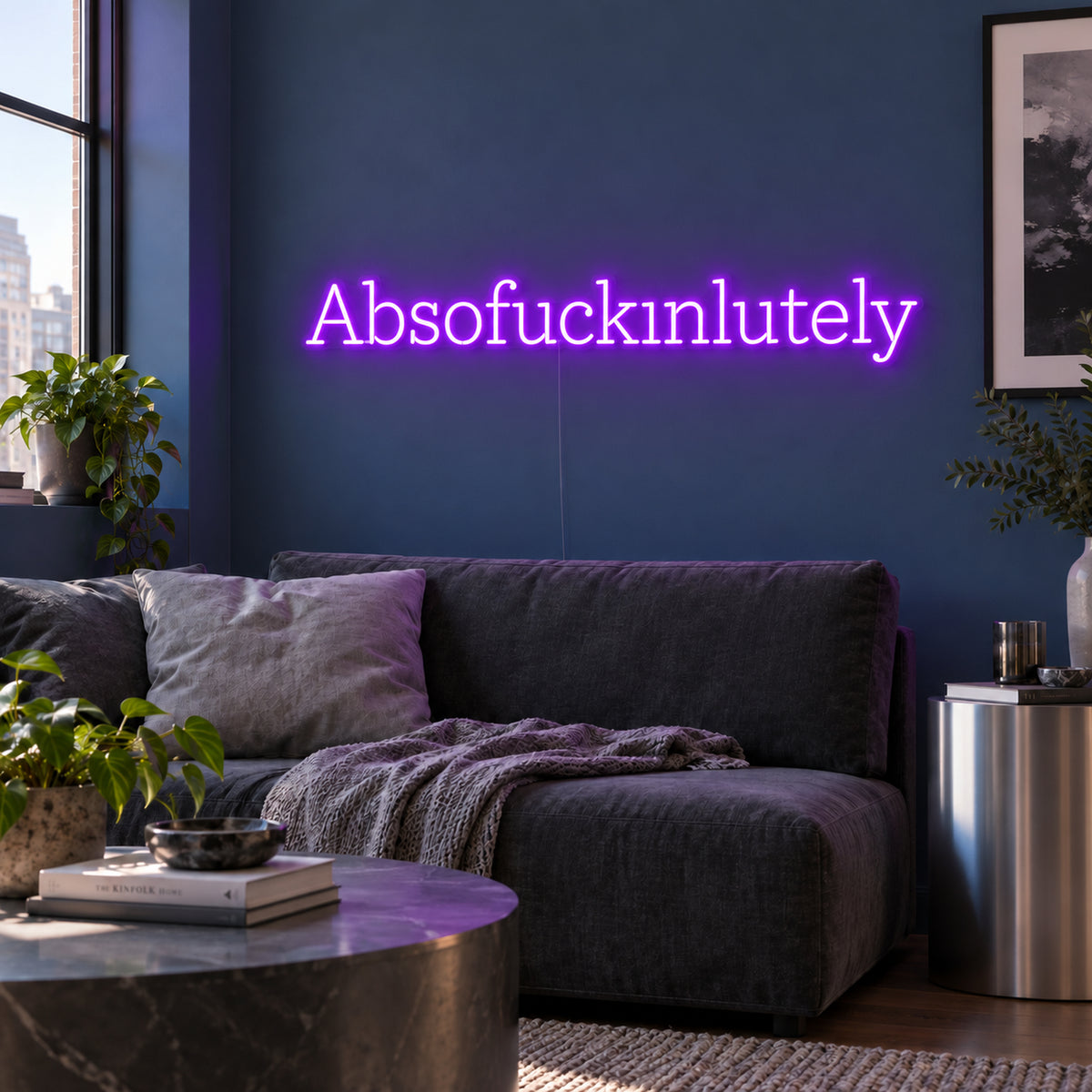 Absofuckinlutely Neon Sign in purple above a charcoal sofa on a blue wall.