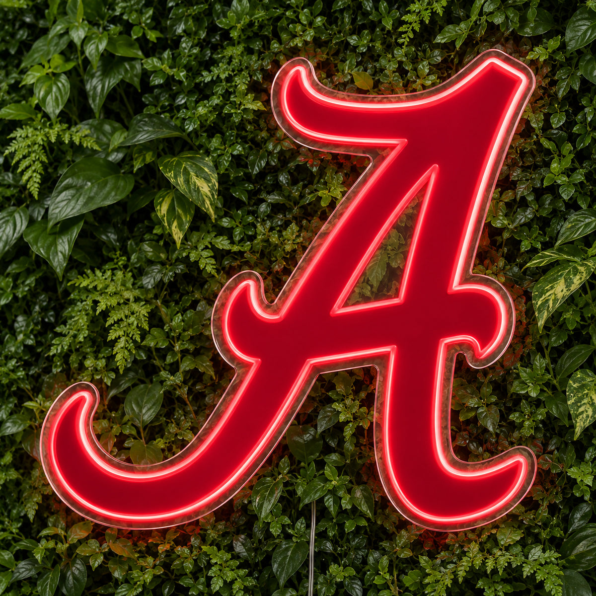 Alabama LED Neon Sign, featuring team logo displayed on a green foliage wall.