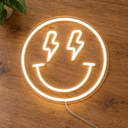 Lightning Smiley Face LED Neon Light Sign in warm white, featuring smiley-face outline with lightning-bolt eyes on a wooden surface.