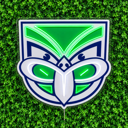 New Zealand Warriors Neon Sign, featuring illuminated team logo on a green foliage wall.