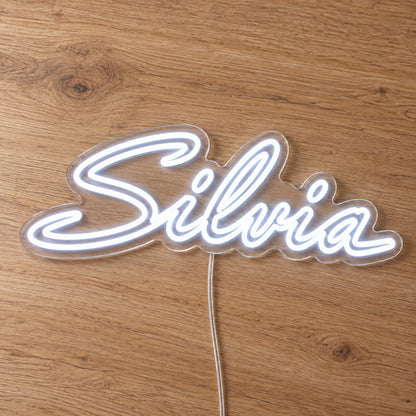 Nissan Silvia LED Neon Sign in white, featuring Silvia script lettering on a wooden surface, close-up view.