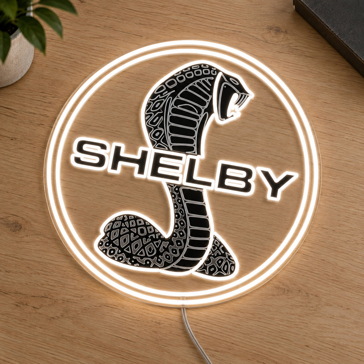 Shelby Cobra LED Neon Sign, featuring illuminated vehicle logo on a wooden surface.