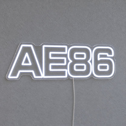 Toyota AE86 LED Neon Sign in white, featuring AE86 lettering on a grey wall.