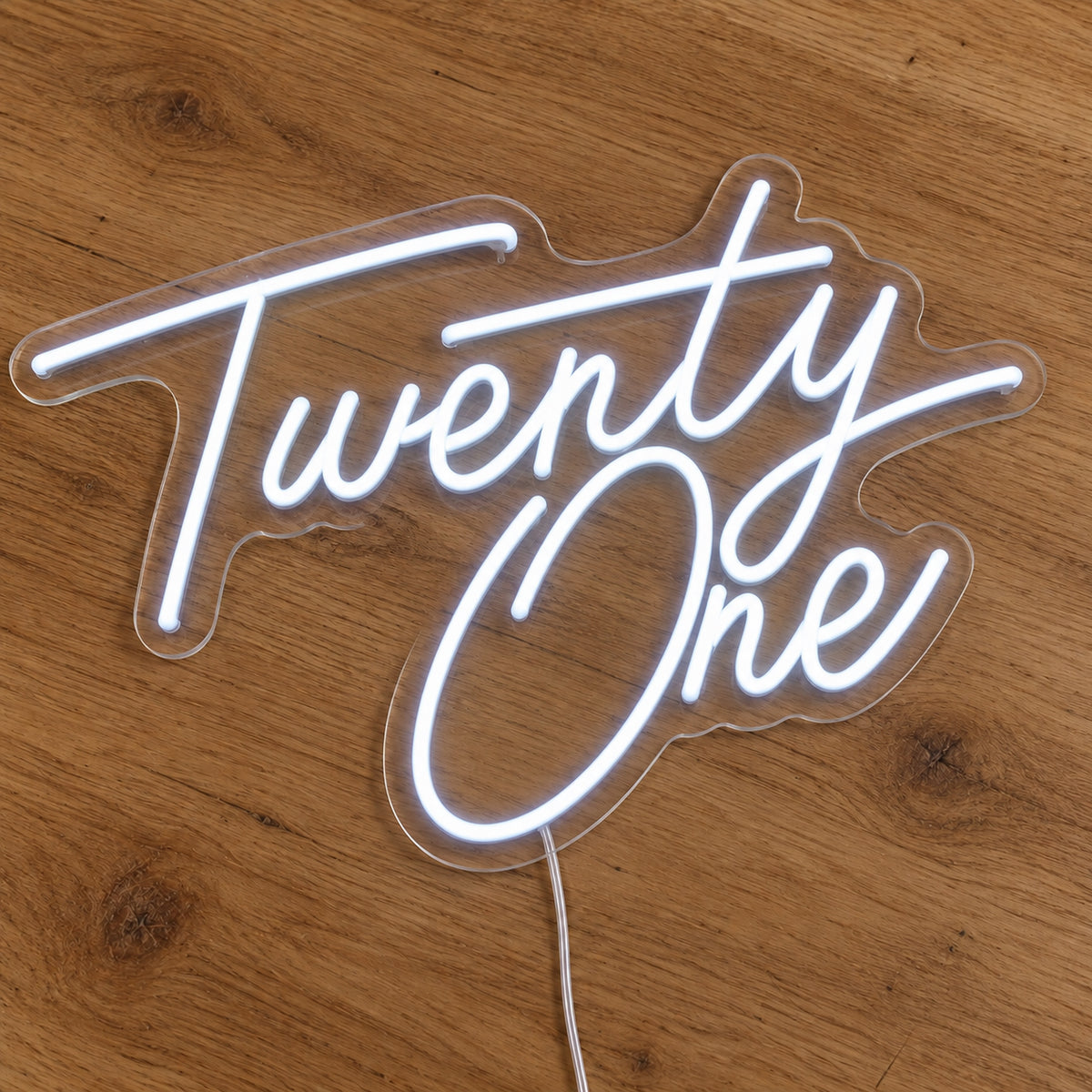 Twenty One LED Neon Sign in white, featuring script lettering on a wooden surface.