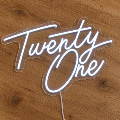 Twenty One LED Neon Sign in white, featuring script lettering on a wooden surface.