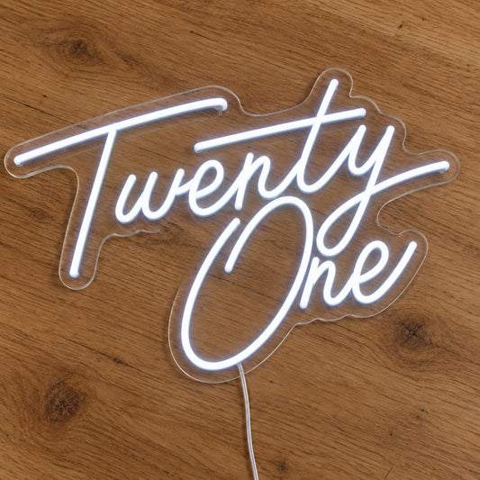 Twenty One LED Neon Sign in white, featuring script lettering on a wooden surface.