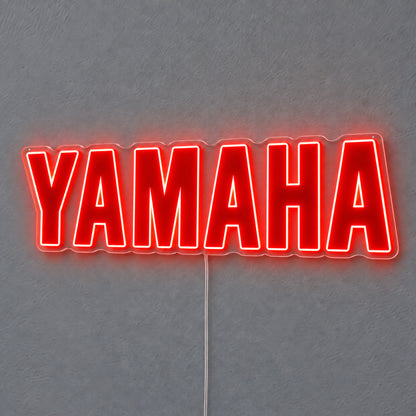 Yamaha (Red) LED Neon Sign in red, featuring Yamaha lettering on a grey wall.