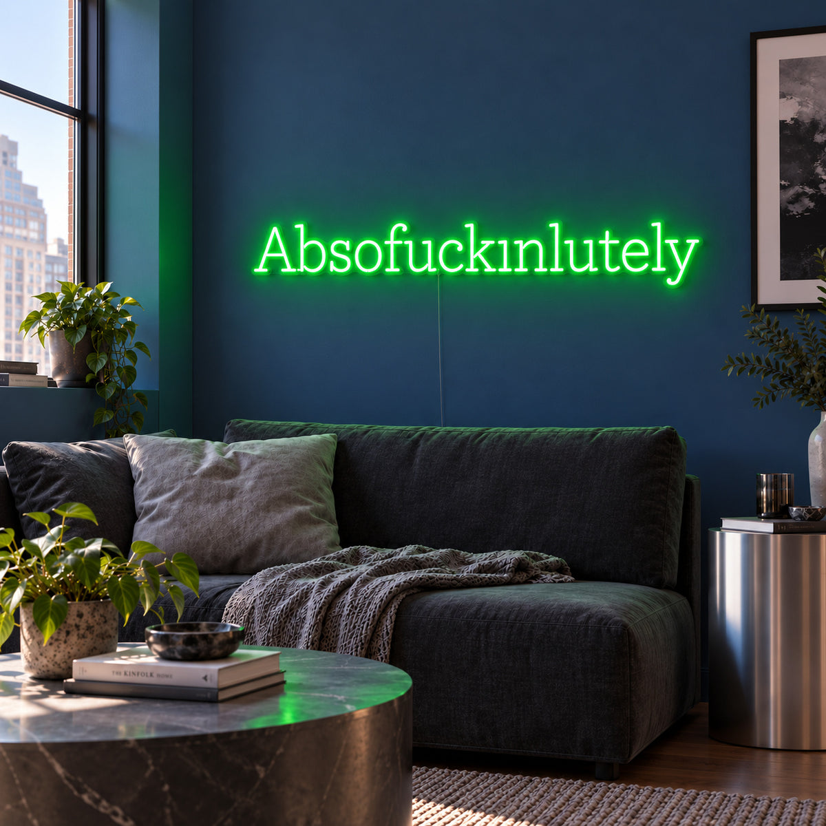 Absofuckinlutely Neon Sign with green lighting, displayed above a charcoal sofa on a blue wall.