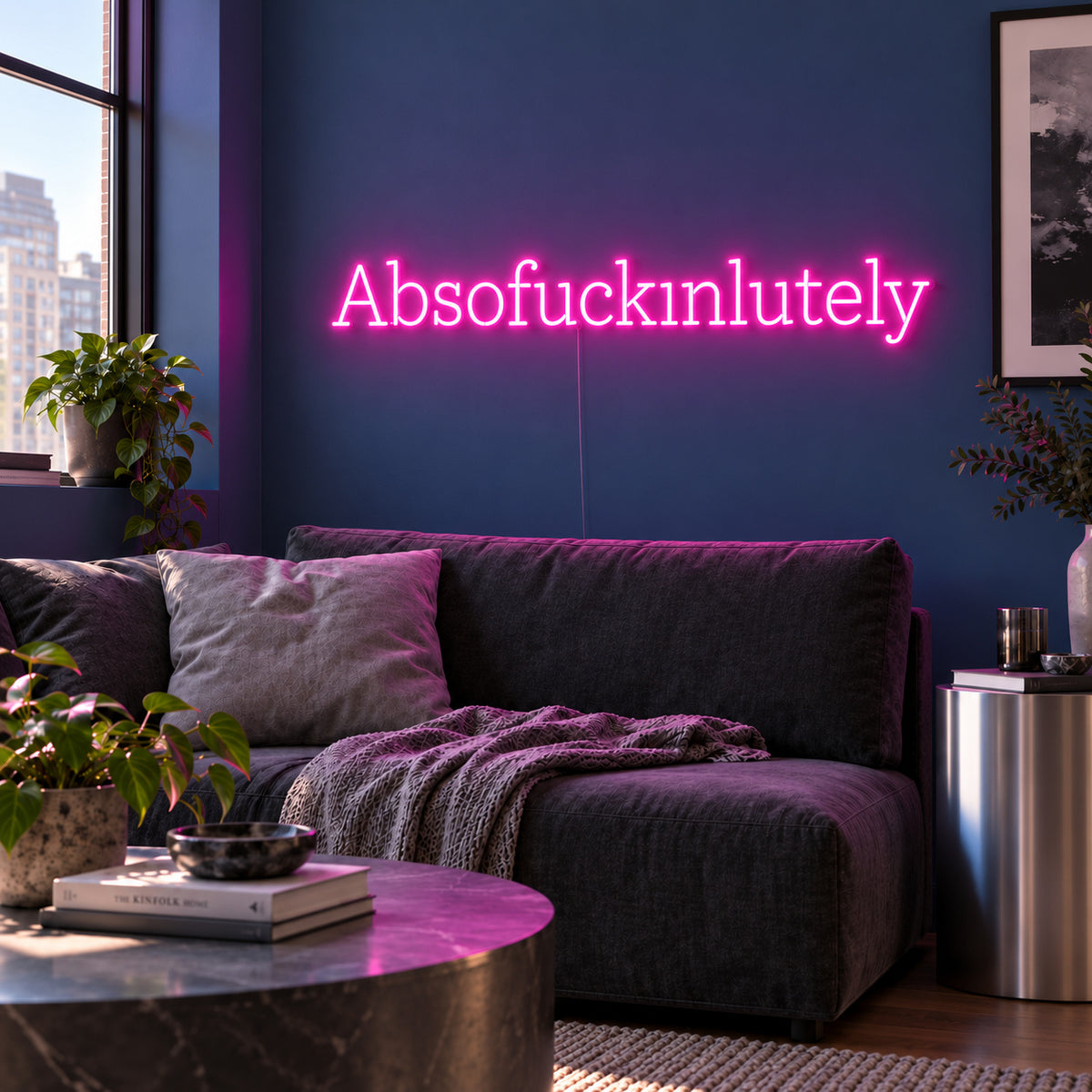 Absofuckinlutely Neon Sign glowing pink above a charcoal sofa on a blue wall.