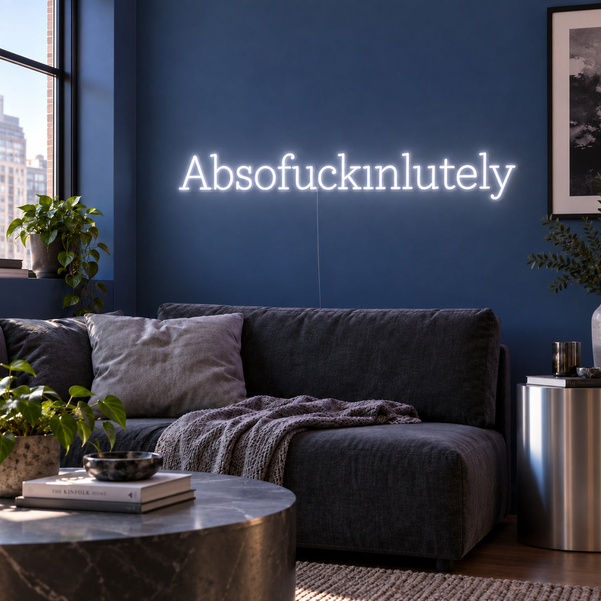 Absofuckinlutely Neon Sign, RGB colour-changing option shown in white above a charcoal sofa on a blue wall.
