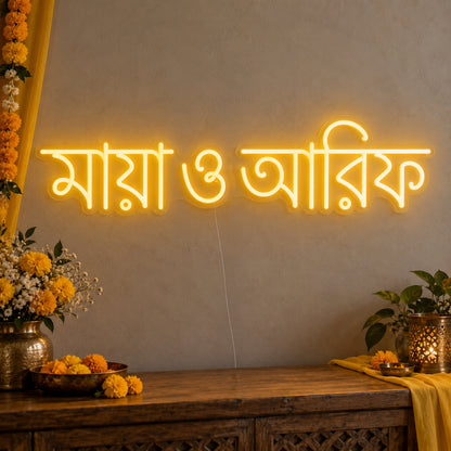 Personalised Bengali Couple Names Neon Sign on clear cut-to-shape acrylic in an illuminated wall display; example personalisation shown.