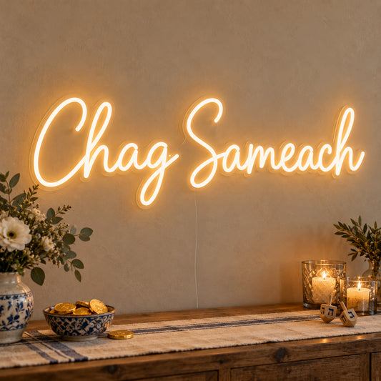 Chag Sameach Neon Sign on clear cut-to-shape acrylic, illuminated on a wall in a styled celebration setting