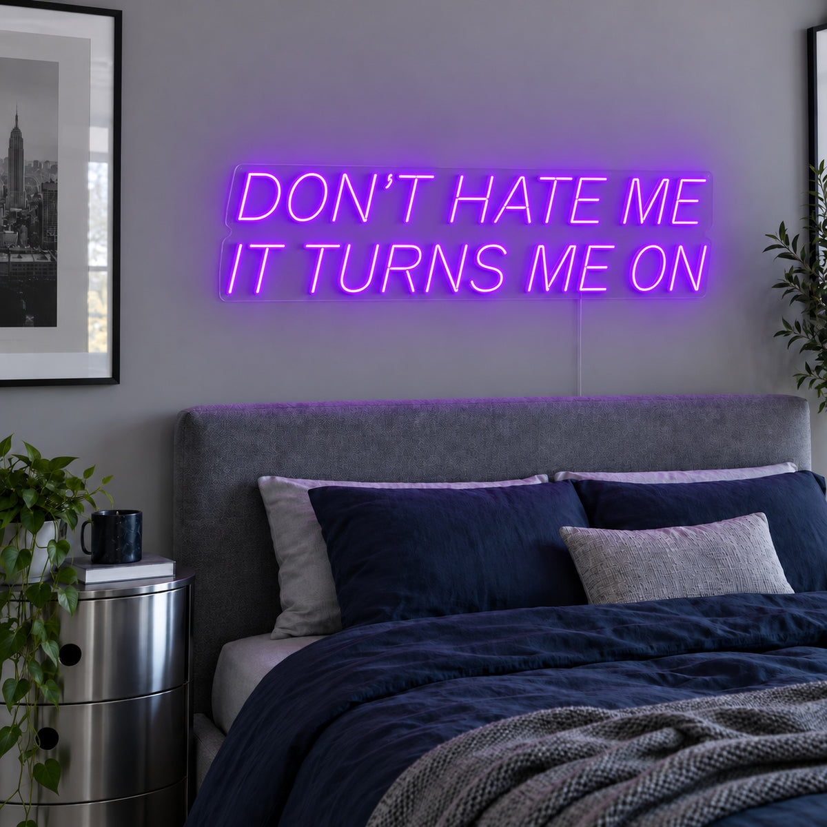 Don't Hate Me It Turns Me On Neon Sign with purple lighting, displayed above a bed with dark blue bedding.