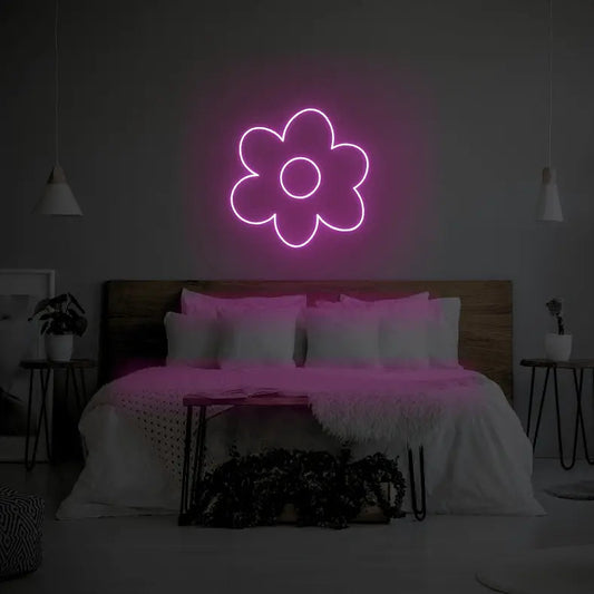 Flower LED Neon Light Sign in pink, featuring flower outline illuminated above a bed.