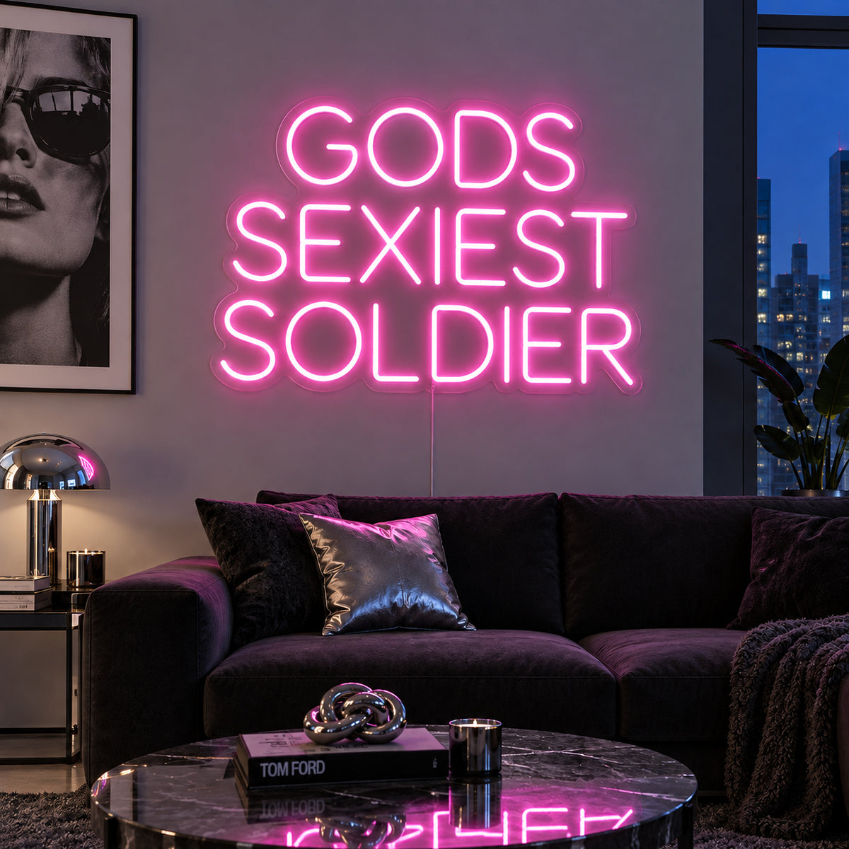 Gods Sexiest Soldier Neon Sign glowing pink in rounded lettering above a dark sofa.