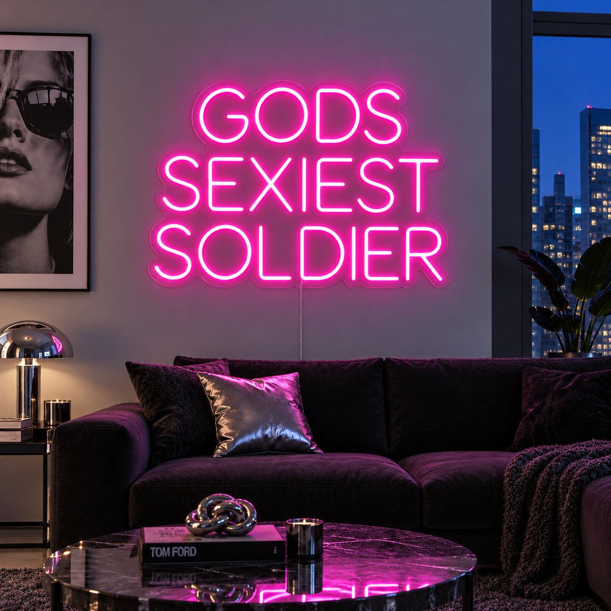 Rose Red version of the Gods Sexiest Soldier Neon Sign, shown in rounded lettering above a dark sofa.