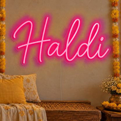 Haldi Neon Sign in rose red LED neon on clear acrylic, angled view