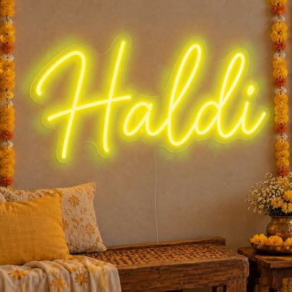 Haldi Neon Sign in yellow LED neon on clear acrylic, angled view