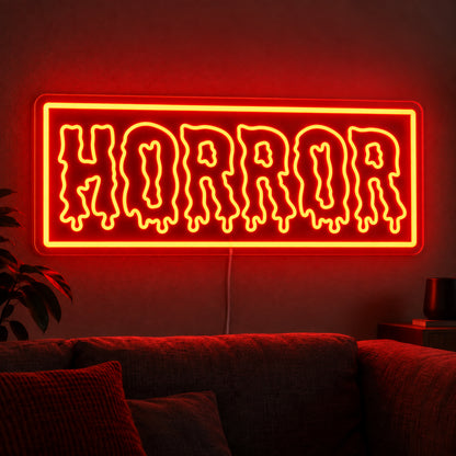 Horror Rectangle Neon Sign featuring dripping Horror lettering inside an orange rectangular border, glowing on a dark living room wall.