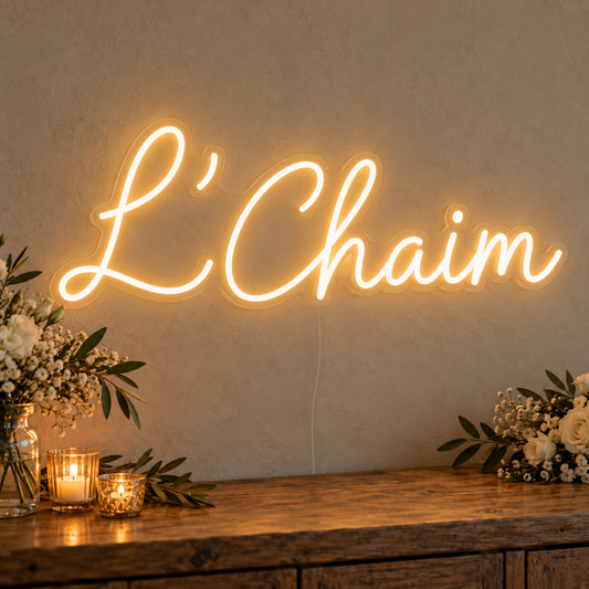 L’Chaim Neon Sign on clear cut-to-shape acrylic, illuminated on a wall in a styled celebration setting