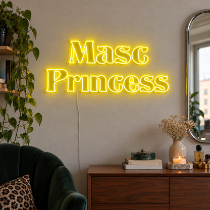 Masc Princess Neon Sign with yellow lighting, displayed above a wooden sideboard beside a green chair.