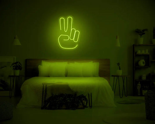 Peace LED Neon Light Sign in green, featuring hand making a peace sign, illuminated above a bed.