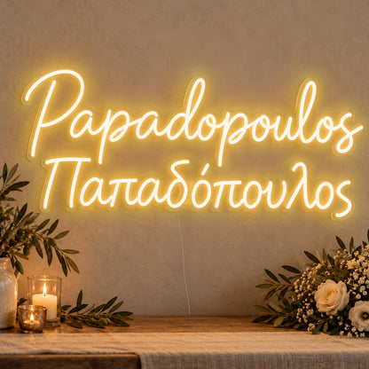 Personalised Bilingual Greek Surname Neon Sign in gold LED neon on clear acrylic, angled view