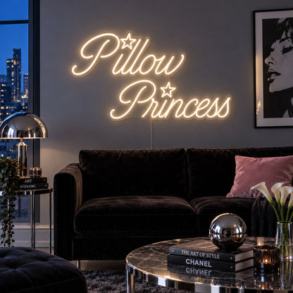 Warm White version of the Pillow Princess Neon Sign, shown with star details above a dark purple sofa.