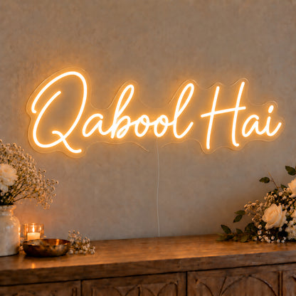 Qabool Hai Neon Sign on clear cut-to-shape acrylic, illuminated on a wall in a styled celebration setting