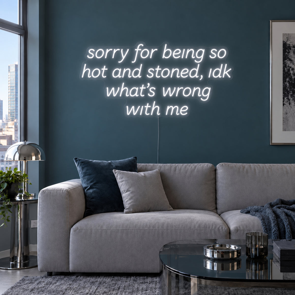 Sorry For Being So Hot And Stoned, Idk What's Wrong With Me Neon Sign in white above a grey sofa against a blue wall.