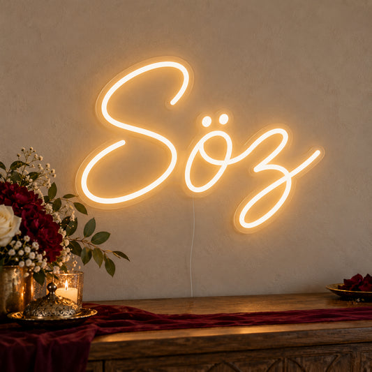 Söz Neon Sign on clear cut-to-shape acrylic, illuminated on a wall in a styled celebration setting