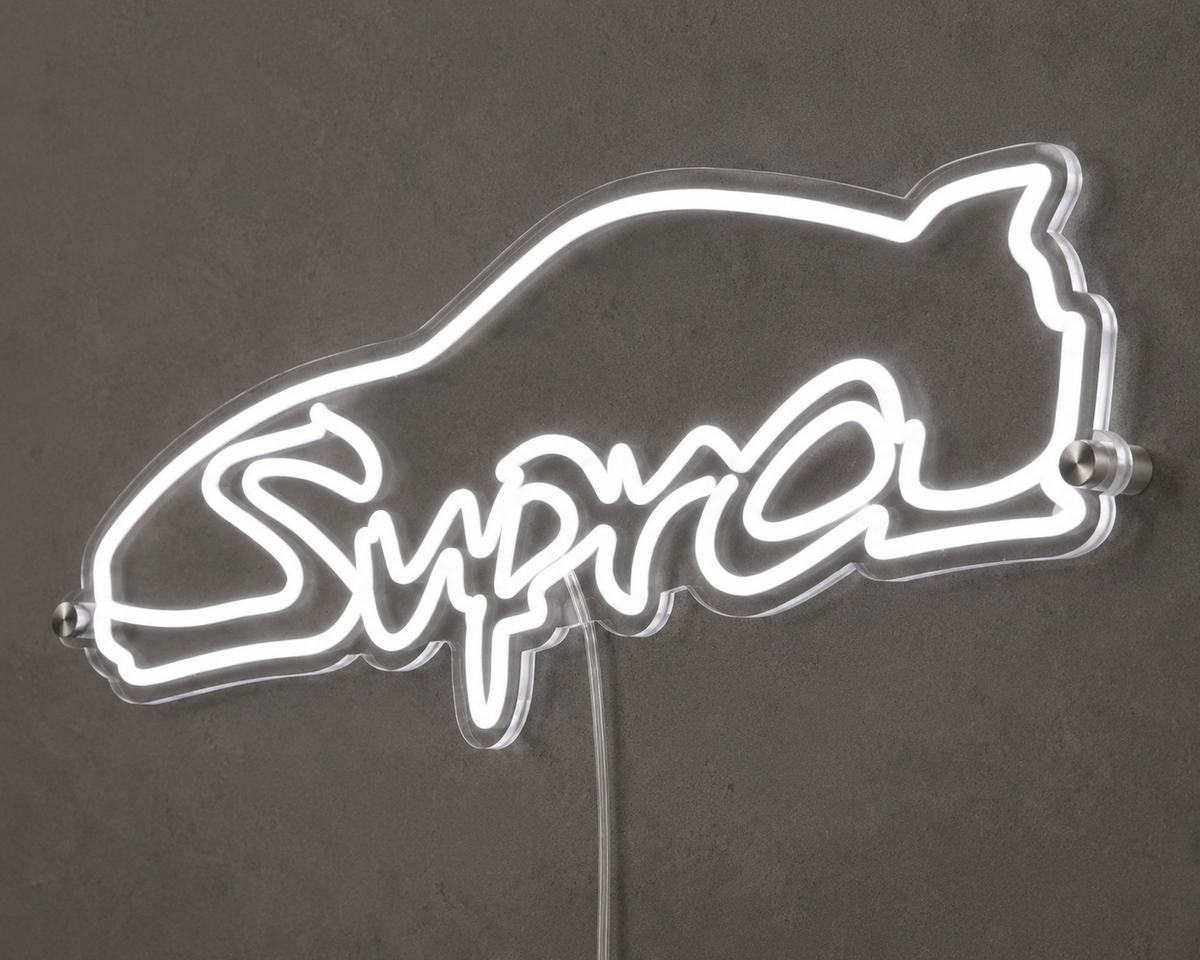 Angled close-up of Supra script neon sign glowing white