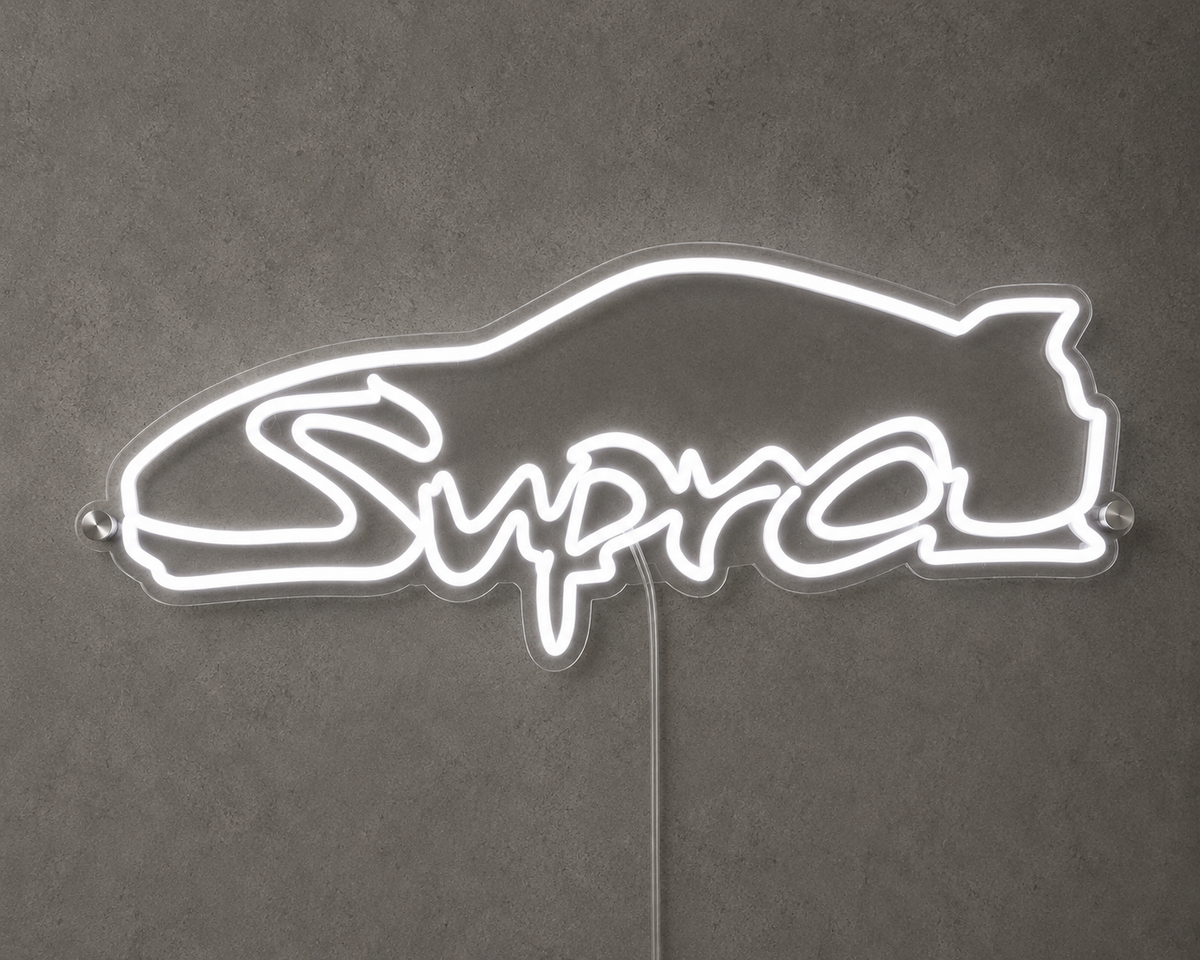 Supra Toyota inspired LED neon sign with white script lettering and car outline on a concrete wall