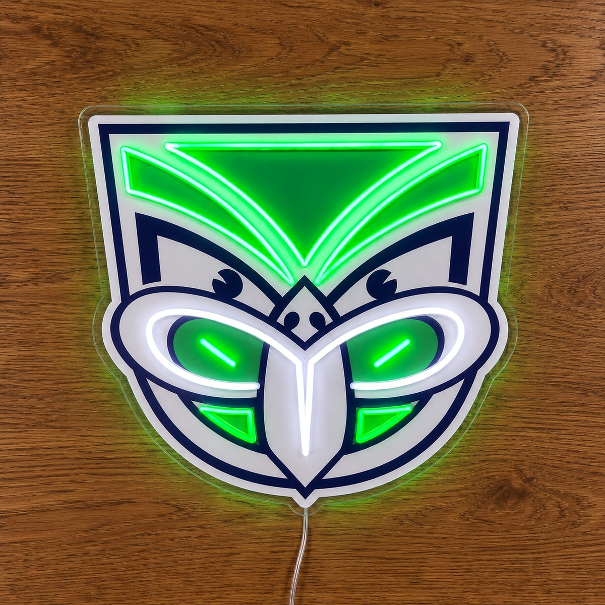 New Zealand Warriors Neon Sign, featuring illuminated team logo on a wooden surface.
