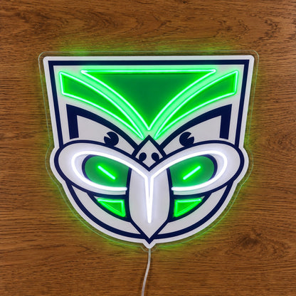 New Zealand Warriors Neon Sign, featuring illuminated team logo on a wooden surface.